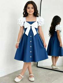 Elladie kids 少女春夏休闲时尚连衣裙，正面饰有白色蝴蝶结，前摆饰有白色金属珍珠纽扣，白色纯色梭织面料，短款泡泡袖拼接蓝色牛仔腰身，适合春夏返校季穿着，甜美可爱，尽显淑女风范，适合日常上学、外出、度假、拍照等春夏穿着。夏季服装，柔软舒适，充满海岛风情，适合海滩周末度假。少女服装，可爱连衣裙。 - 中等水洗藍 - 查看 10