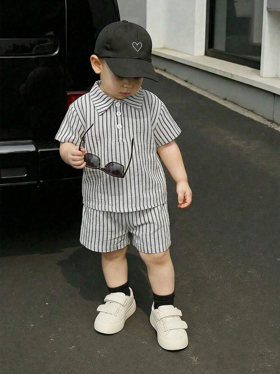Souflis Souflis 这款男婴条纹短袖套装,采用简约经典的灰白条纹交织设计,搭配领口和纽扣细节,尽显可爱气质。泡泡袖上衣和配套条纹短裤柔软舒适,是理想的夏季穿搭之选。 - 彩色 - 查看 1