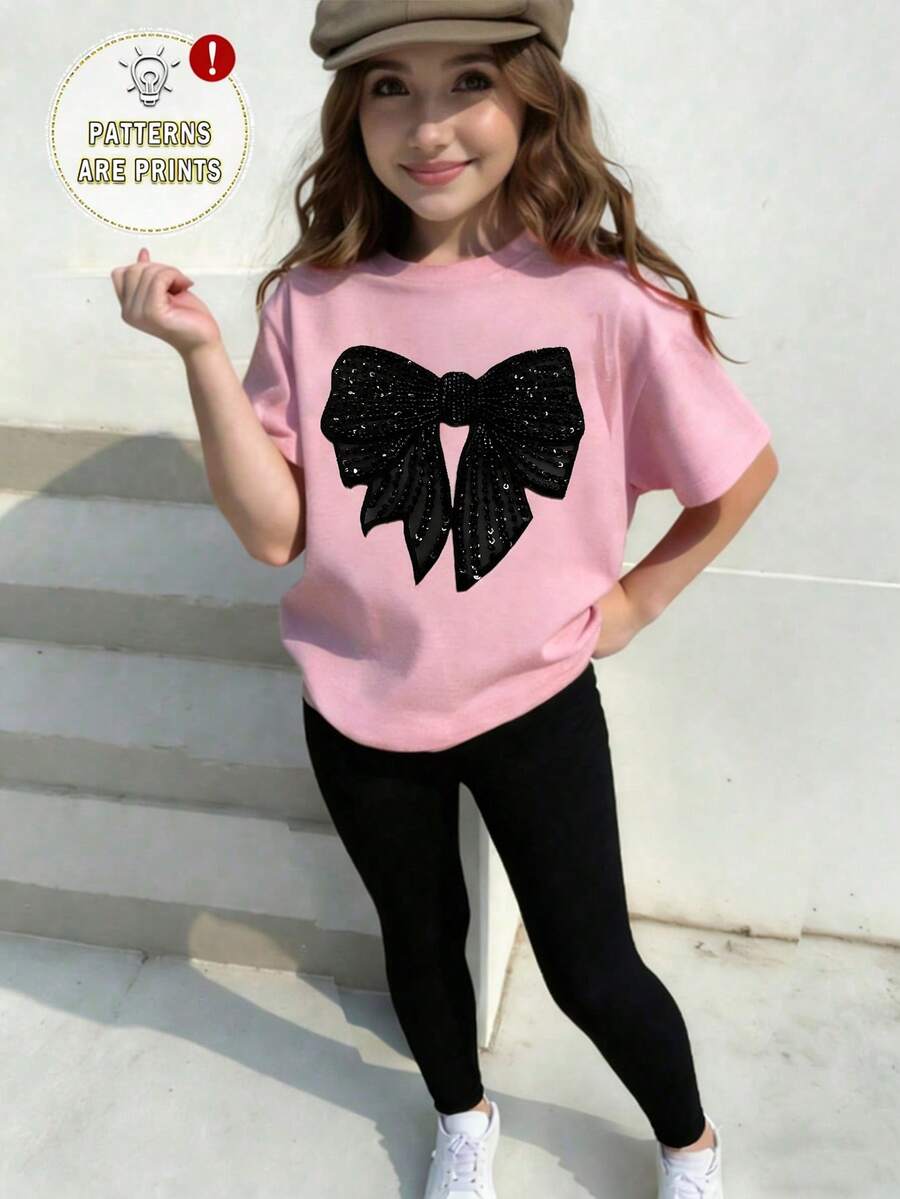 SHEIN Sparklyn Bộ đồ thể thao mùa xuân hè cho bé gái, phong cách thường ngày sáng tạo, cá tính, tối giản, điểm nhấn là nơ đen bóng, in họa tiết đồ họa, gồm áo thun và quần legging, thoải mái để mặc hàng ngày. - Nhiều màu - Xem 1