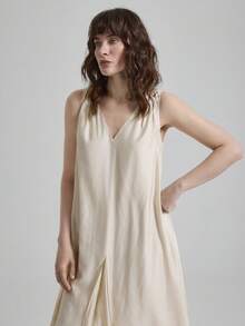 女士天丝亚麻灰色连衣裙，采用舒适亲肤的高端莱赛尔纤维面料，双面V领设计，前后均有褶裥，A字版型，配有侧袋，适合现代都市商务休闲、办公室穿着、通勤、高品质机场穿搭、低调复古风、邮轮装扮，尽显简约奢华感，是四季皆宜的百搭连衣裙，属于都市主题系列。 - 杏色 - 查看 4