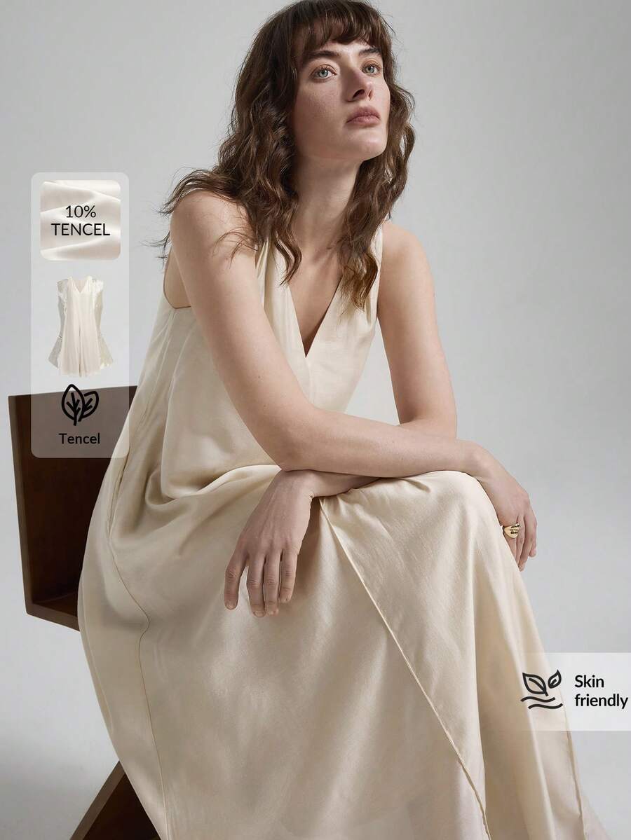 女士天丝亚麻灰色连衣裙，采用舒适亲肤的高端莱赛尔纤维面料，双面V领设计，前后均有褶裥，A字版型，配有侧袋，适合现代都市商务休闲、办公室穿着、通勤、高品质机场穿搭、低调复古风、邮轮装扮，尽显简约奢华感，是四季皆宜的百搭连衣裙，属于都市主题系列。 - 杏色 - 查看 1