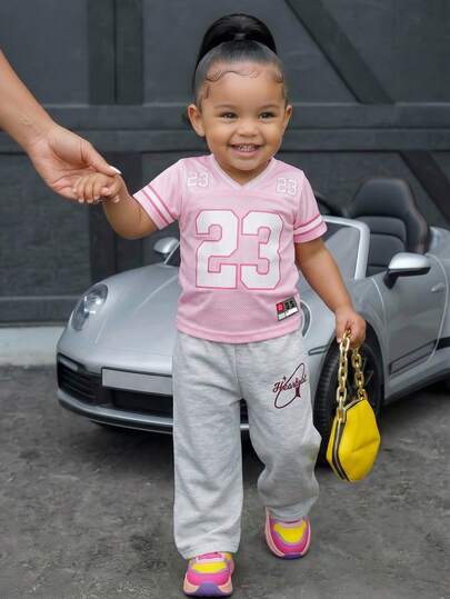 SHEIN 两件套婴幼儿女童运动休闲套装，粉色数字印花白色撞色V领短袖T恤搭配灰色印花长裤，适合日常穿着、运动赛事和街头风格。