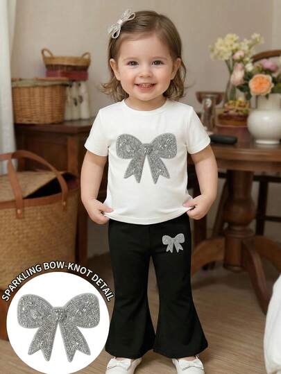 SHEIN Bộ 2 món cho bé sơ sinh và trẻ nhỏ 0-3 tuổi, gồm áo thun ngắn tay cổ tròn có nơ và quần ống loe, kiểu dáng rộng rãi thoải mái cho mùa hè, có thể mặc thêm lớp vào mùa thu, trang phục thường ngày thời trang cho trẻ em với họa tiết dễ thương.