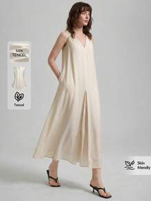 女士天丝亚麻灰色连衣裙，采用舒适亲肤的高端莱赛尔纤维面料，双面V领设计，前后均有褶裥，A字版型，配有侧袋，适合现代都市商务休闲、办公室穿着、通勤、高品质机场穿搭、低调复古风、邮轮装扮，尽显简约奢华感，是四季皆宜的百搭连衣裙，属于都市主题系列。 - 杏色 - 查看 2