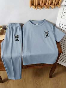 SHEIN 两件装青少年男童休闲运动学院风复古圆领卡其色T恤和长裤套装，饰有章节装饰，适合儿童穿着，幼儿男童服装，返校季男童套装，适合生日派对、晚宴、演出、婚礼、洗礼、开幕式等场合，日常穿着也适合上学、旅行、运动，适合春夏季节，母亲节/母女装。 - 淺藍色 - 查看 2