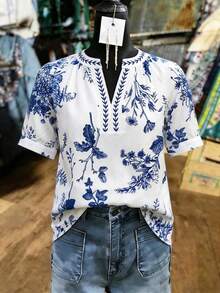 Franclia 这款别致的波西米亚风白色布料衬衫，短款泡泡袖，V领设计，饰有蓝色花卉图案，是女士的理想之选。这款短袖衬衫款式多样，包括V领、印花等，是夏季女士衬衫的完美搭配。 - 白色 - 查看 1