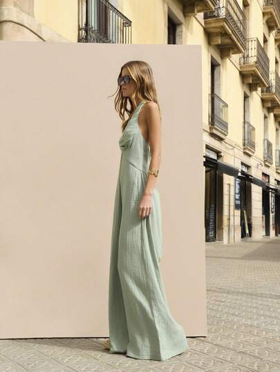 Nöista Light Green Cotton-Linen Wide-Leg Jumpsuit Is Elegant, Featuring An Off-The-Shoulder Halter Neck, A Knotted Front, And A Wide-Leg Cut. Made From Natural Fabric In A Soft Color, It Exudes A Casual And Vacation Vibe, Suitable For Various Occasions In Spring And Summer.