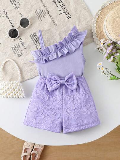 女童夏季两件套：吊带荷叶边背心 + 压花蝴蝶结短裤，甜美清新的紫色罗纹面料套装。柔软面料背心，3D压花短裤，时尚简约，适合幼儿园、度假、海滩、公园、家庭聚会等场合，夏季穿着舒适，甜美清新，时尚显瘦，幼儿套装，罗纹面料，压花面料，荷叶边，蝴蝶结装饰，吊带设计，室内外皆宜