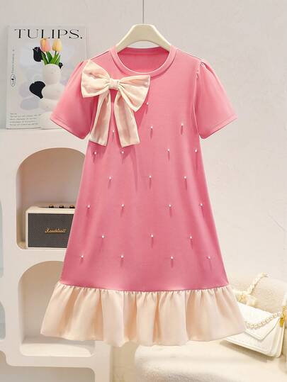 SHEIN Vestido de punto de estilo escolar elegante y casual para niñas preadolescentes. Presenta un cuello redondo de color rojo sandía, mangas cortas, un lazo de color albaricoque contrastante en la parte delantera, adornos de perlas, un bajo plisado y mangas abullonadas para un aspecto elegante. Adecuado para salidas diarias, la escuela, vacaciones al aire libre y diversas ocasiones, es perfecto para la primavera y el verano.