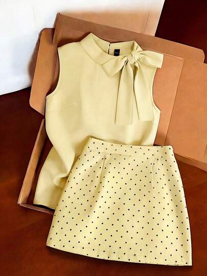 Franclia Light Gray Commuter Outfit, Sleeveless Turtleneck Top Paired With Polka Dot Mini Skirt. Minimalist Fitted Silhouette Accentuates The Waistline. Soft, Draping Fabric. Bow Detail On Top And Evenly Distributed Polka Dots On Skirt Showcase Refined Craftsmanship, Simple Yet Elegant Style.