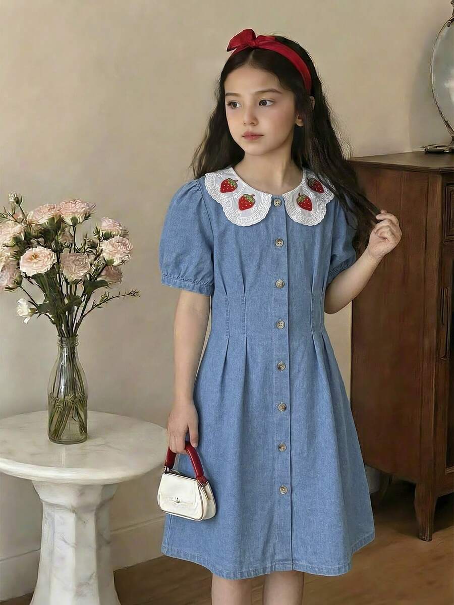 SHEIN Vintaside Kids 少女牛仔连衣裙，夏季新品，时尚休闲风。浅牛仔蓝，荷叶边领口和3D草莓刺绣，腰部系带褶皱设计，时尚修身。采用轻盈柔软的棉质牛仔面料，舒适亲肤。女孩必备单品，简约休闲，适合夏季穿着，百搭实用，可用于日常穿着、拍照、外出、派对、音乐节、度假等多种场合。