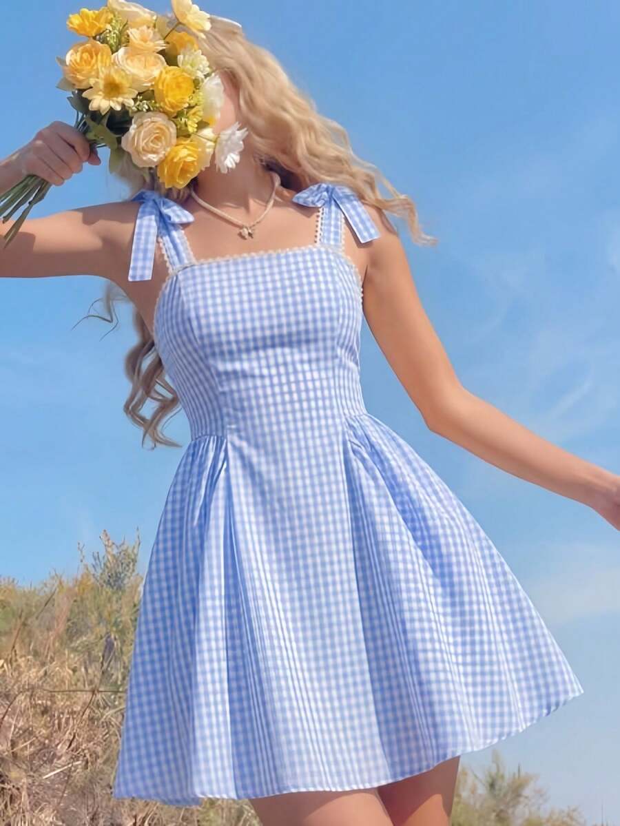 SHEIN 这款少女清新黄色格子吊带连衣裙采用黄白小格子面料，搭配方领和蝴蝶结肩带装饰，散发着法式甜美气息；收腰设计和独特的裙摆剪裁融合了休闲元素。它是近年来流行的精致女装，适合夏季日常穿着。 - 藍色 - 查看 1
