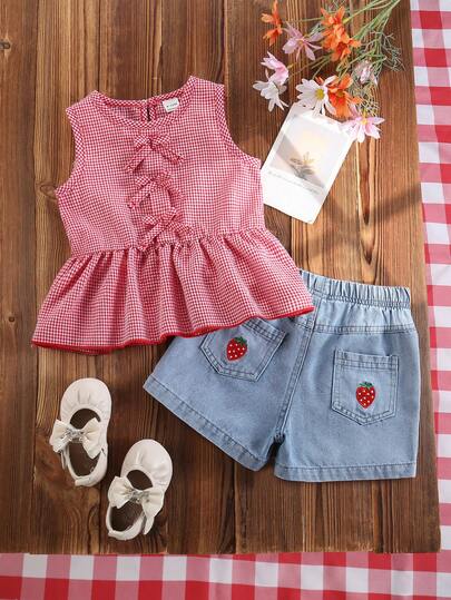 SHEIN Vintaside Kids Bộ đồ hai mảnh cho bé gái gồm áo tunic không tay cổ tròn kẻ caro đỏ trắng mùa hè và quần short denim co giãn. Đây là kiểu dáng cổ điển, đa năng, tươi mới và mang phong cách đồng quê học đường. Áo dáng rộng, có nơ trang trí phía trước và thiết kế xếp ly ở gấu quần. Túi sau của quần short denim được thêu họa tiết dâu tây.