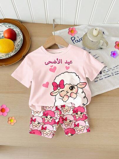SHEIN Bộ áo thun ngắn tay cổ tròn dáng rộng thoải mái màu hồng kem, in hình cừu dễ thương, và quần short đạp xe cho bé gái, thích hợp mặc hàng ngày vào mùa xuân/hè, phong cách đường phố, đi chơi, nghỉ lễ, họp mặt, tựu trường.