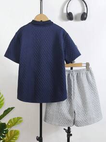 SHEIN Streecool Kids 两件套男童竖条纹短袖衬衫和灰色休闲短裤套装，亲肤透气。衬衫采用多色竖条纹设计，配有小翻领和短袖；短裤采用松紧腰带。整体休闲度假风格，适合日常穿着、幼儿园、海滩旅行等场合。可整套穿着，也可分开搭配，打造阳光活力的儿童造型，时尚的返校套装。 - 藏蓝色 - 查看 2