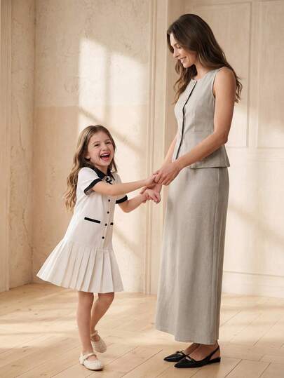SHEIN Đầm bé gái dáng lửng, cổ bẻ, thắt eo, màu be chủ đạo phối cổ áo đen tương phản, nơ, cúc phía trước và chân váy xếp ly, thanh lịch nhưng vẫn trẻ trung, tay ngắn, thích hợp mặc vào mùa xuân/hè. Phù hợp cho các hoạt động ở trường, tiệc sinh nhật, họp mặt gia đình, đi làm, v.v. Đầm hè ngọt ngào, thanh lịch.