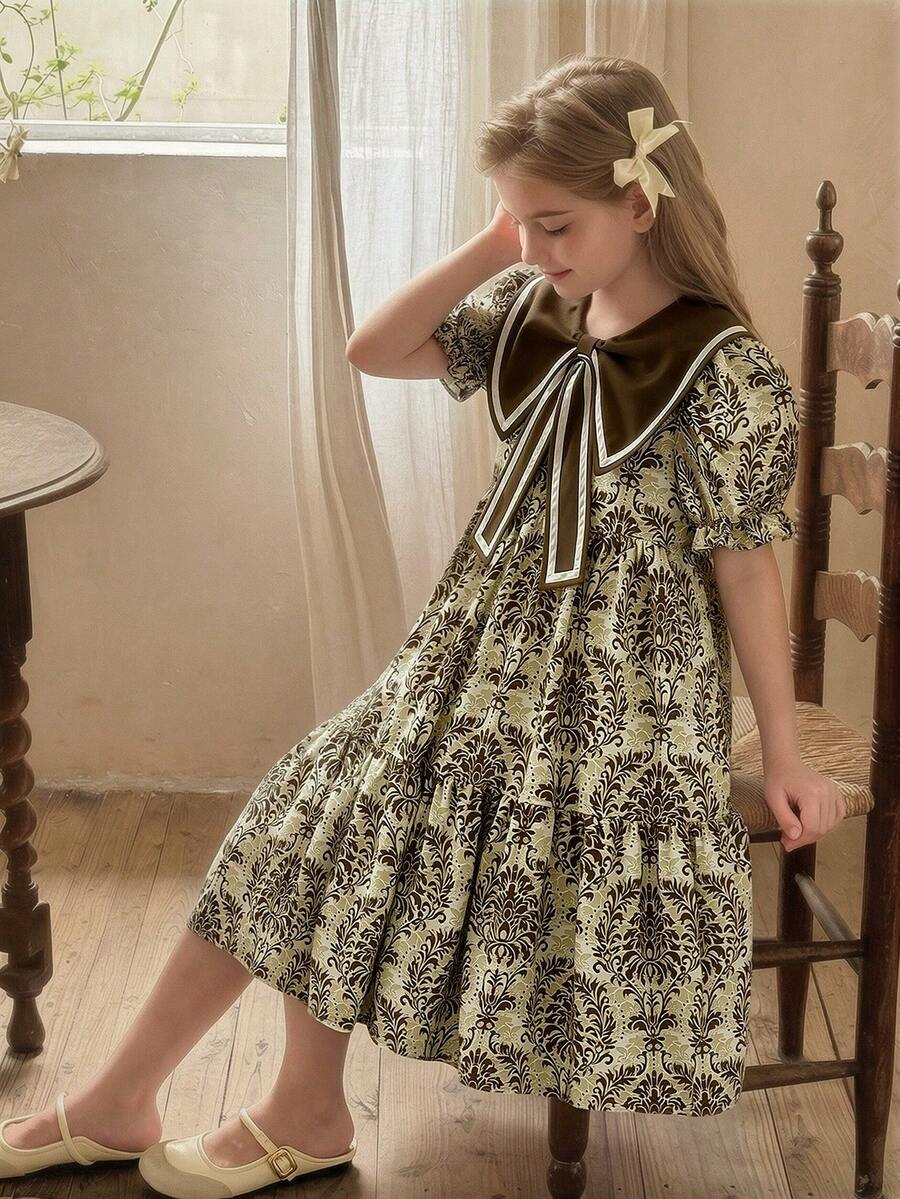 SHEIN Vintaside Kids Đầm hè kiểu bohemian ngọt ngào cho bé gái, họa tiết hoa màu xanh dương, cổ áo nơ lớn, tay ngắn và dáng suông dài đến đầu gối. Hoàn hảo cho mặc hàng ngày, đi mua sắm, đi biển, du lịch và nhiều hoạt động khác. - Rỉ Nâu - Xem 1