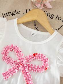 SHEIN Bộ đồ thời trang dễ thương cho bé gái gồm áo thun cổ tròn tay loe viền nơ 3D và quần short vạt bất đối xứng in họa tiết kẻ caro hồng trắng, thích hợp cho mùa hè. - Nhiều màu - Xem 3