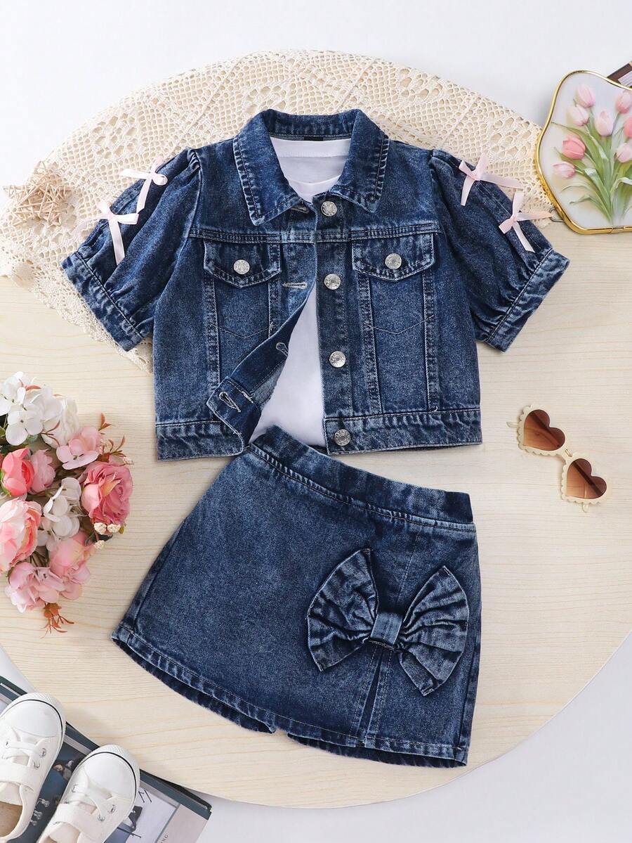 SHEIN Bộ đồ hè 2 mảnh Denimly dành cho bé gái. Phong cách nghỉ dưỡng ngọt ngào và dễ thương, kết hợp với vẻ ngoài năng động, thoải mái. Màu xanh nhạt. Thiết kế tay phồng đáng yêu và tinh nghịch. Điểm nhấn là chiếc nơ 3D màu hồng ở cổ tay, tạo nên vẻ tươi tắn và ngọt ngào. Áo tay ngắn cổ bẻ nhỏ. Kết hợp với chân váy denim, chiếc nơ 3D lớn phía trước rất bắt mắt. Thiết kế xẻ tà, eo chun co giãn tạo sự thoải mái và tôn dáng. Thích hợp cho các buổi đi chơi, hẹn hò, nghỉ mát biển, tụ tập bạn bè, đi học. Tạo nên vẻ ngoài ngọt ngào mùa hè.