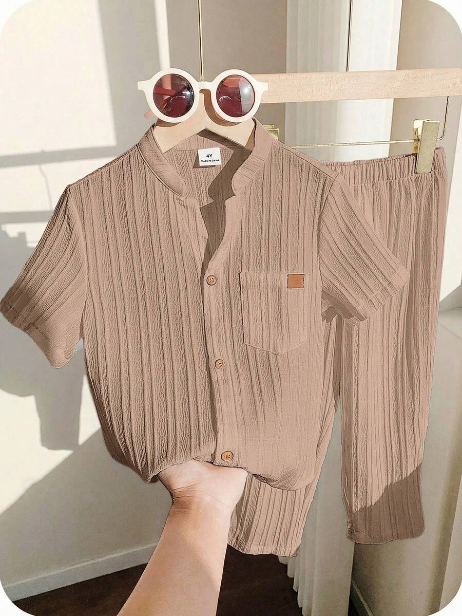 SHEIN 两件装男童休闲运动套装,包括一件立领衬衫和一条裤子,采用纹理面料,适合儿童穿着,是男童返校的理想选择。套装也适合生日派对、晚宴、演出、婚礼、洗礼、开幕式等场合,日常穿着舒适,适合上学、旅行、运动,尤其适合春夏季节。 - 卡其色 - 查看 1