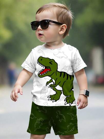 SHEIN Bộ 2 món cho bé trai, gồm áo thun cổ tròn tay ngắn và quần short in hình khủng long dễ thương theo phong cách graffiti, kiểu dáng thể thao, phù hợp cho mùa xuân/hè, thời trang đường phố.