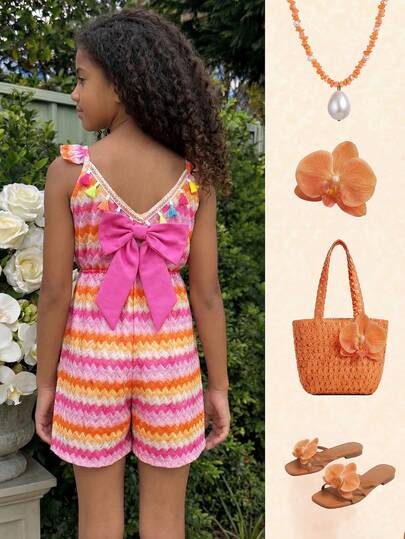 SHEIN Đây là bộ áo liền quần một mảnh thời trang và thoải mái dành cho bé gái và trẻ nhỏ. Áo được làm từ vải thun co giãn chải kỹ với họa tiết sọc sóng nhiều màu sắc, kiểu dáng rộng rãi và thoải mái, cùng với cạp chun co giãn giúp điều chỉnh kích cỡ vòng eo. Phần lưng được trang trí bằng những tua rua ngắn nhiều màu sắc và một chiếc nơ lớn màu hồng cánh sen có thể tháo rời, thể hiện phong cách nghỉ dưỡng. Áo phù hợp để mặc hàng ngày, đi chơi, dự tiệc, đi nghỉ mát và du lịch, là một món đồ mùa hè chất lượng cao và đa năng.