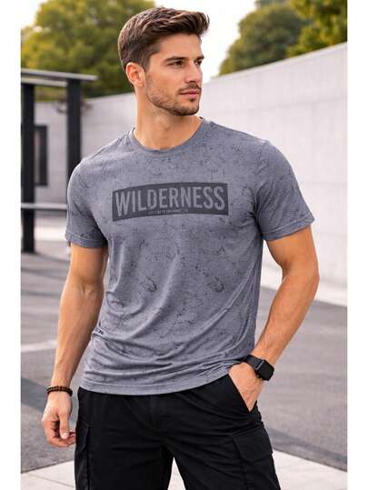 Playera manga corta gris estampado Wilderness estilo urbano casual para hombre, diseño moderno con efecto desgastado, tela cómoda y ligera ideal para uso diario, outfit streetwear versátil para combinar con jeans o shorts.