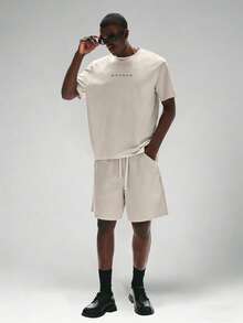 STYNVO Bộ áo thun cổ tròn in chữ và quần short rộng dành cho nam. - Màu be - Xem 2