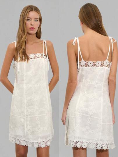 Nöista 白色迷你连衣裙，饰有花卉刺绣，修身胸衣搭配柔和的A字裙摆。采用直领设计，配有可调节系带和扇形蕾丝裙边。是夏季活动、度假或特殊场合的完美之选。
