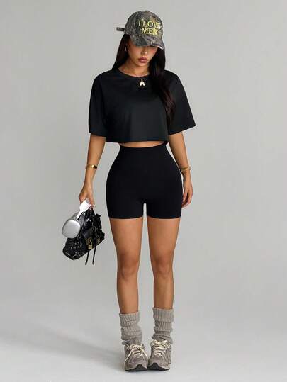 Dewbera Bộ gồm 1 áo khoác ngắn tay màu đen, áo ngực không đường may màu đen và quần short.