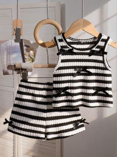 Elladie kids Bộ áo len kẻ sọc đen trắng kiểu công chúa ngọt ngào, được làm từ chất liệu vải cotton mềm mại, thoáng khí; họa tiết kẻ sọc ngang đen trắng cổ điển với điểm nhấn nơ tinh tế, áo không tay cổ tròn + quần short cùng màu, dáng rộng rãi thoải mái, kiểu dáng ngọt ngào và thanh lịch, phù hợp cho mặc hàng ngày, dã ngoại gia đình, tiệc sinh nhật, v.v., thời trang và tiện dụng, một bộ trang phục trẻ em bán chạy cho mùa xuân, hè và thu.