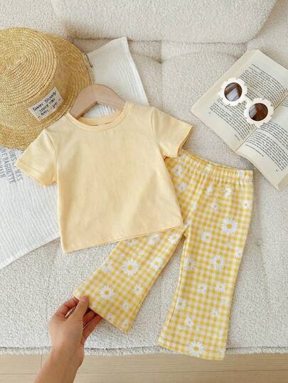 Bộ đồ bé gái kiểu dáng tối giản gồm áo thun ngắn tay cổ tròn và quần ống loe, thích hợp cho mùa xuân/hè.