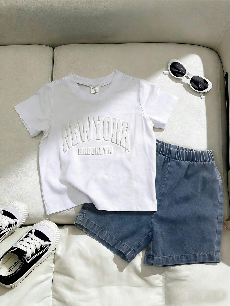 SHEIN Playful Pals Set de 2 piezas de moda minimalista para niño pequeño de primavera/verano: Parte superior de manga corta con cuello redondo en tela de punto color albaricoque con estampado en relieve de letras inglesas, combinada con pantalones cortos de mezclilla elásticos en la cintura. Versátil y adecuado para actividades al aire libre y vacaciones de niños pequeños. - Blanco - Ver 1