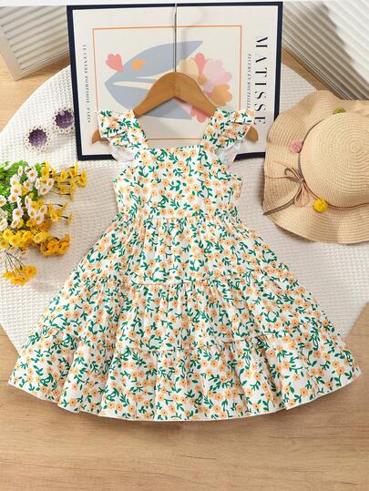 Vintaside Kids 清新可爱的女童连衣裙：白色底布上印有橙色花朵和绿色枝条，柔和的色调展现活力；方领搭配荷叶袖，俏皮又显肩部线条；双层荷叶边裙摆，蓬松轻盈，行走间更显动感。透气面料，甜美可爱，是春夏的理想之选。