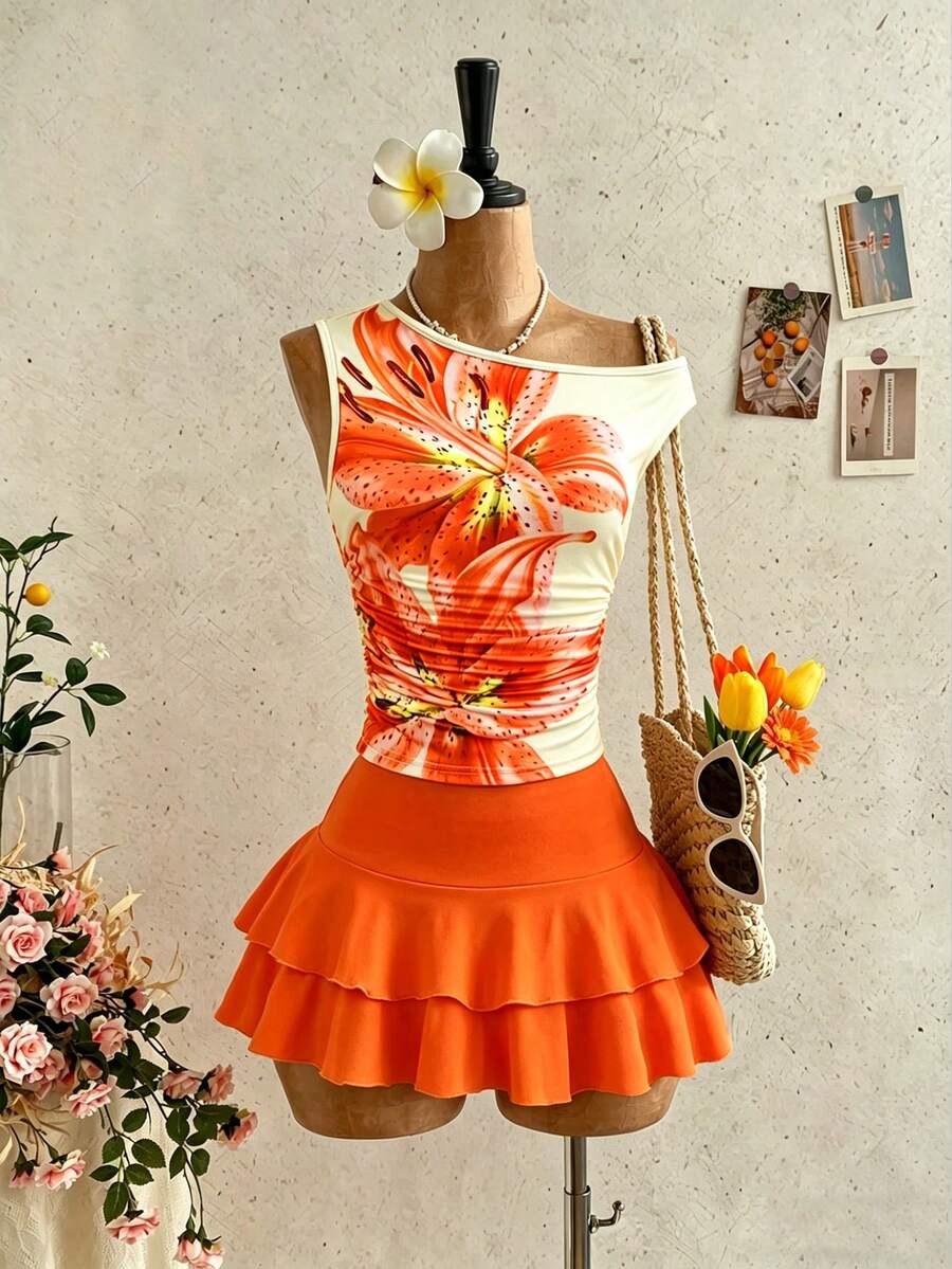 SHEIN Sparklyn Este conjunto de dos piezas para adolescentes presenta un estilo de vacaciones elegante y casual para niñas y adolescentes, con una parte superior con hombros descubiertos y una falda de volantes. La parte superior tiene un gran estampado floral en el frente, exudando encanto, y el diseño único de los hombros descubiertos es tanto individual como elegante. La falda tiene un dobladillo de doble capa con detalles de recogido, lo que la hace suelta y cómoda. Es adecuado para salidas diarias, viajes, vacaciones y otras ocasiones, convirtiéndolo en un atuendo de verano imprescindible. - Naranja Coral - Ver 1