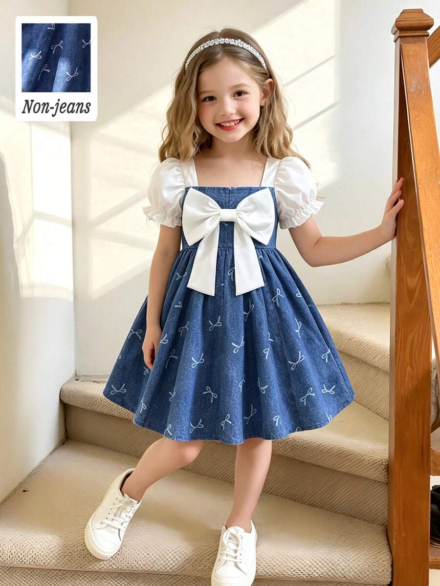 Elladie kids 女童春夏连衣裙，正面饰有白色蝴蝶结，梭织面料，白色泡泡袖短袖，拼接蝴蝶结印花图案蓝色牛仔效果面料腰部连衣裙，面料柔软舒适，适合年轻女孩穿着，优雅可爱，休闲时尚，适合日常、上学、外出、度假、派对等场合。