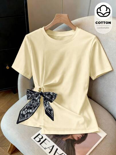 Franclia 2026 New Summer Style Women's Round Neck Short-Sleeved T-Shirt Side Twist Design Waist Slimming Top Niche Design Silk Scarf Bow Decorated Irregular Hem T-Shirt Large Size Fat Mm Covering The Flesh And Slimming Style Commuting Versatile Casual Cotton T French Temperament Sweet Girl Style Daily Wear Can Be Worn Outside Slim Slimming Short Sleeves Multi-Color Optional Basic Design T-Shirt Breathable And Comfortable Pure Cotton Top In Summer