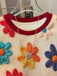 Blusa feminina adolescente com estampa floral miúda texturizada e vintage em vermelho, modelagem solta, blocos de cores contrastantes e gola redonda. Ideal para o verão, uso diário, volta às aulas, looks com as irmãs, férias e Dia dos Namorados. - Multicolorido - Ver 3