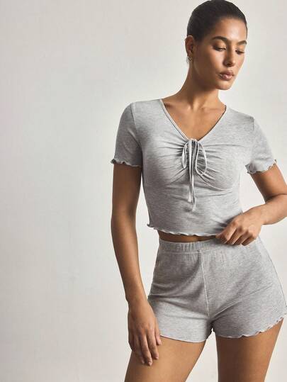 Ocili Bộ đồ ngủ nữ kiểu dáng thoải mái, gồm áo cổ chữ V có dây rút và quần short, chất liệu mềm mại, phù hợp cho cả mặc trong nhà và ngoài trời.