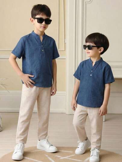 SHEIN 两件装男童休闲运动套装，包括一件立领衬衫和一条裤子，采用纹理面料，适合儿童穿着，是男童返校的理想选择。套装也适合生日派对、晚宴、演出、婚礼、洗礼、开幕式等场合，日常穿着舒适，适合上学、旅行、运动，尤其适合春夏季节。