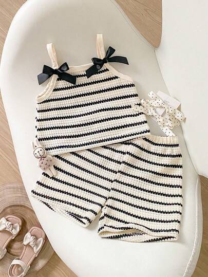 Bộ áo hai dây và quần short phối màu tương phản có nơ dành cho bé gái.