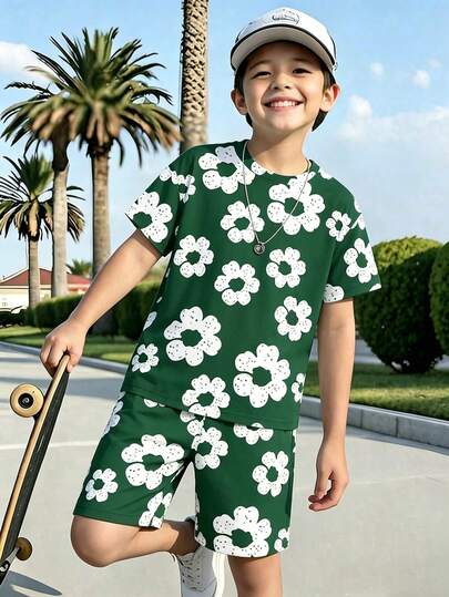 Conjunto de camiseta básica de manga corta y pantalones cortos casuales con estampado de flores blancas grandes sobre base verde, de estilo minimalista y personalidad creativa, para niños en primavera y verano, cómodo para uso diario