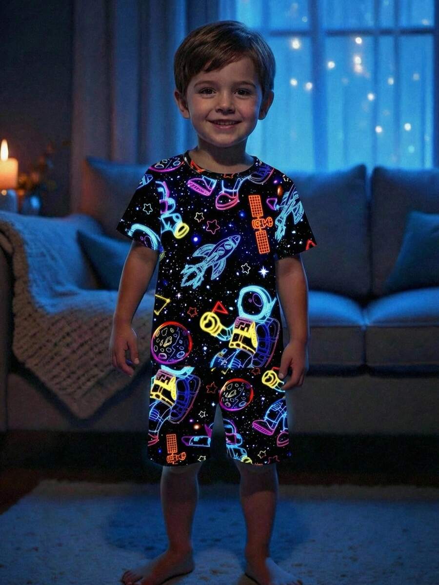 SHEIN Bubblio 2 piezas Conjunto de pijama ajustado y cómodo para niños pequeños con camiseta de manga corta de cuello redondo y estampado brillante en la oscuridad de dibujos animados del espacio, y pantalones cortos