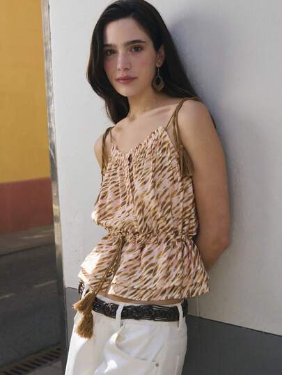 Nöista Top sin mangas con un estampado abstracto en tonos suaves de marrón y beige. Presenta tirantes ajustables con borlas y una cintura ceñida con cordón para un ajuste favorecedor. Perfecto para un festival de música, estilo bohemio, verano, primavera, ropa de playa, fiesta en la piscina, look diario.