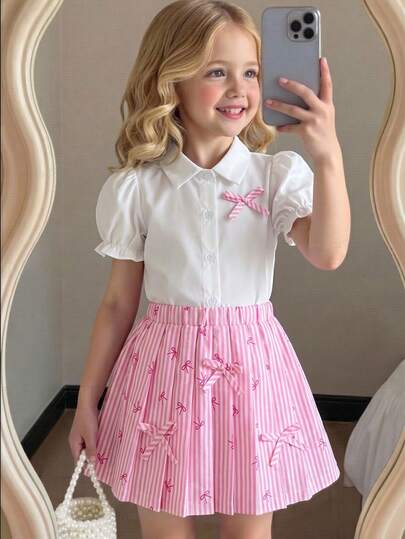 Elladie kids Bộ 2 món áo sơ mi thắt nơ và chân váy xếp ly cho bé gái, mùa xuân/hè. Áo sơ mi tay phồng màu trắng kết hợp với chân váy xếp ly kẻ sọc hồng trắng, trang trí bằng nơ bướm cùng màu, phong cách năng động và ngọt ngào cho bé gái, phù hợp cho các hoạt động hàng ngày, công viên giải trí, họp mặt gia đình và nhiều dịp khác.
