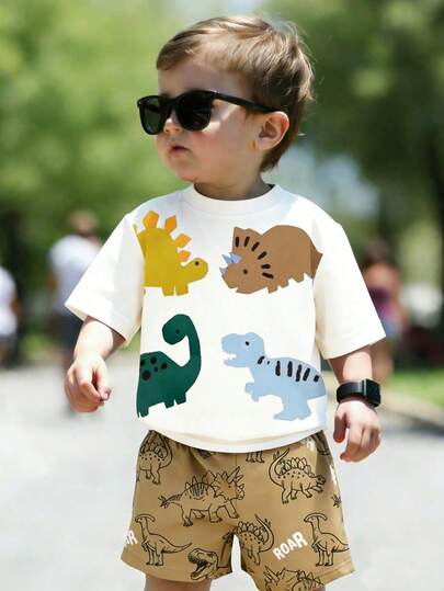 Bộ đồ thể thao thường ngày cho bé trai, gồm áo thun cổ tròn và quần short in hình khủng long hoạt hình dễ thương, thích hợp cho mùa hè.
