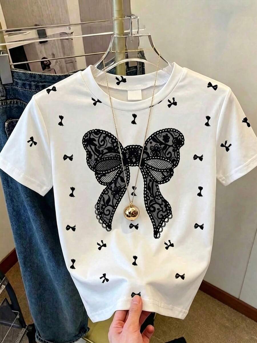 SHEIN Genkimix Kids 女童夏季白色短袖T恤,可爱宽松蕾丝图案蝴蝶结印花,圆领柔软透气,俏皮时尚,适合派对、学校假期、休闲日常穿着,高品质基础款童装。 - 黑與白 - 查看 1