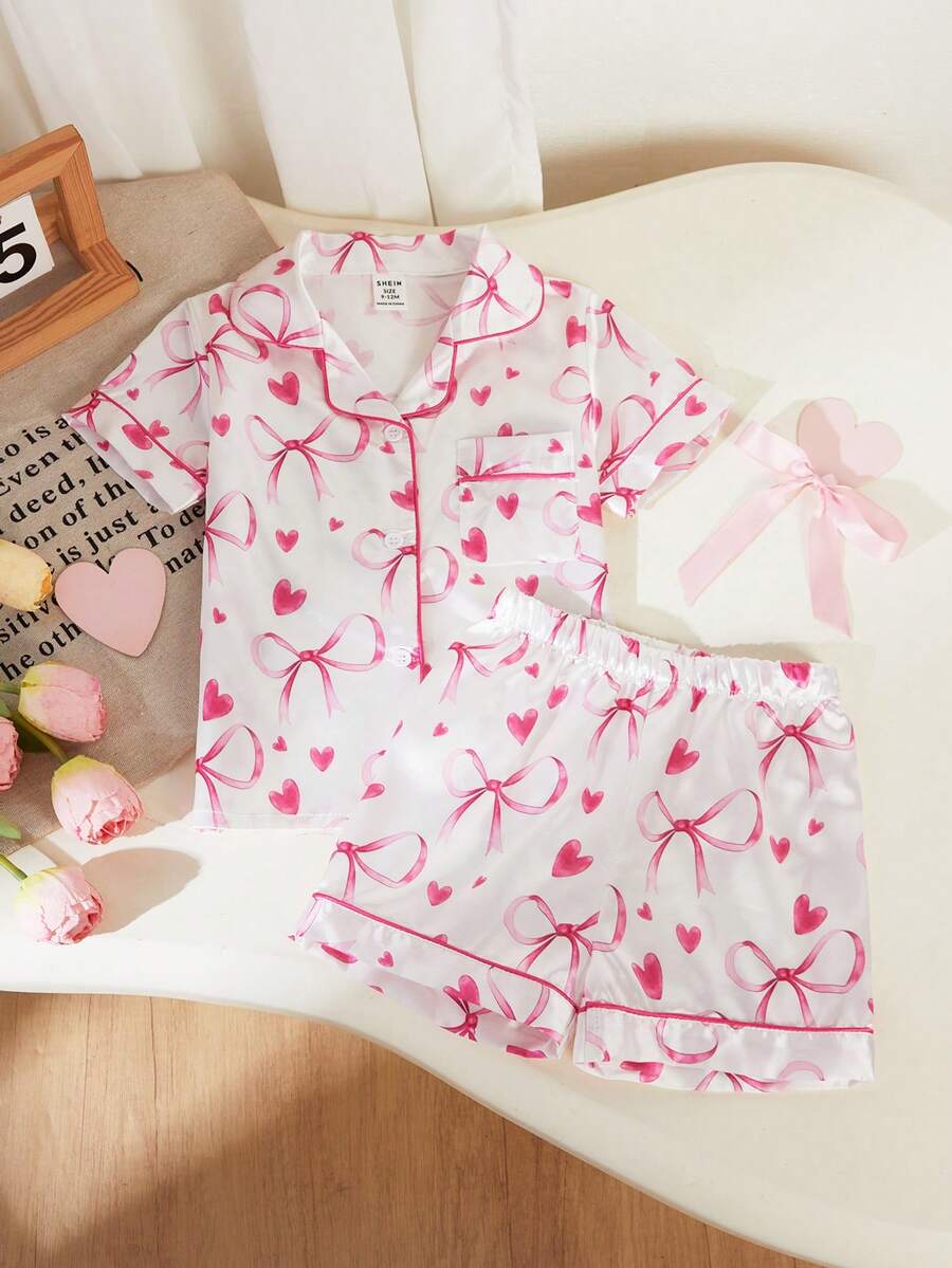 SHEIN Conjunto de pijama de 2 piezas para niñas bebé, con top de manga corta con cuello de solapa y abotonado, y pantalones cortos. Estampado de corazones, lazos y letras de amor en rosa y blanco. Conjunto de ropa de dormir y uso en casa cómodo, suave, transpirable y elegante para niños y niñas pequeñas. - Blanco - Ver 1