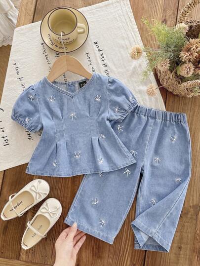 Baby Girls' Denim Set. New Summer Collection. Fashionable Casual Style. Short Sleeve Top + Denim Pants 2-Piece Set. Medium Blue Wash, Waist Ruffle Design With Cute Bow Embroidery. Loose A-Line Silhouette. Elastic Waistband. Lightweight Soft Cotton Denim Fabric, Comfortable And Skin-Friendly. A Must-Have For Fashionable Girls. Minimalist Casual Suitable For Summer, Suitable For Daily Wear, Photo Shooting, Outing, Party, Music Festival, Vacation, Etc. New Arrival Toddler Girls' Denim Set