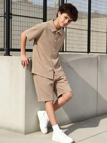 SHEIN Vacaura Bộ đồ đôi cho bé trai gồm áo sơ mi ngắn tay và quần short dệt kim kẻ sọc dọc, chất liệu pha trộn, thân thiện với da và thoáng khí. Áo có thiết kế kẻ sọc dọc nhiều màu với cổ áo nhỏ và tay ngắn; quần short có chun co giãn. Phong cách thường ngày phù hợp cho kỳ nghỉ, đi nhà trẻ, đi biển, v.v. Có thể mặc cả bộ hoặc riêng lẻ để tạo nên một bộ trang phục trẻ em năng động, tươi sáng, một bộ đồ thời trang cho năm học mới. - Màu Khaki - Xem 1